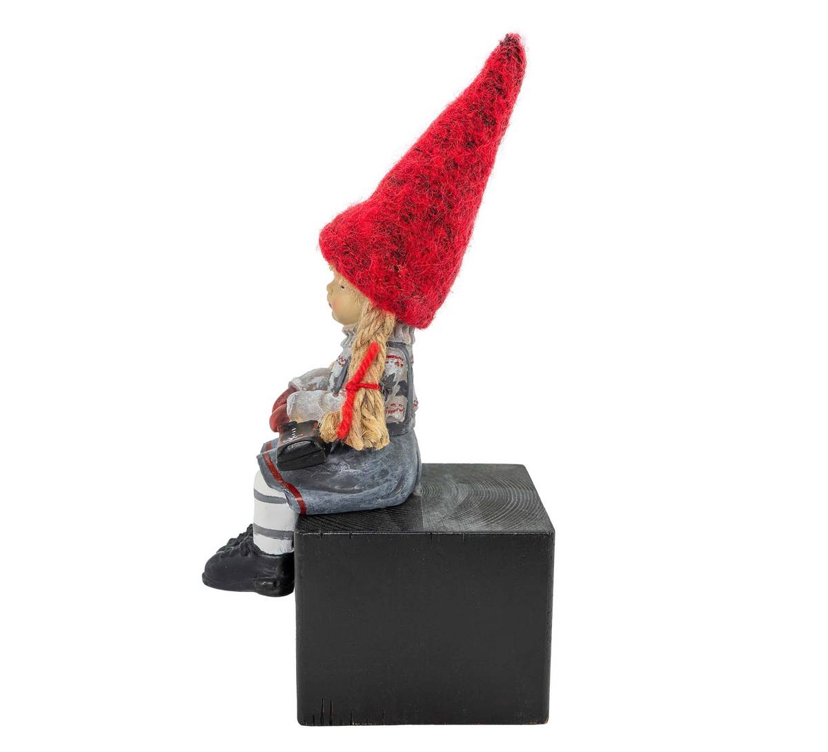 Girl sitting and holding skis, red hat